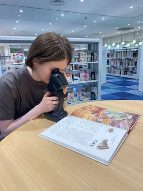 机に置かれた雑誌を読むためにレティッサオンハンドを使っている女性 机に置かれた雑誌を読むためにレティッサオンハンドを使っている女性